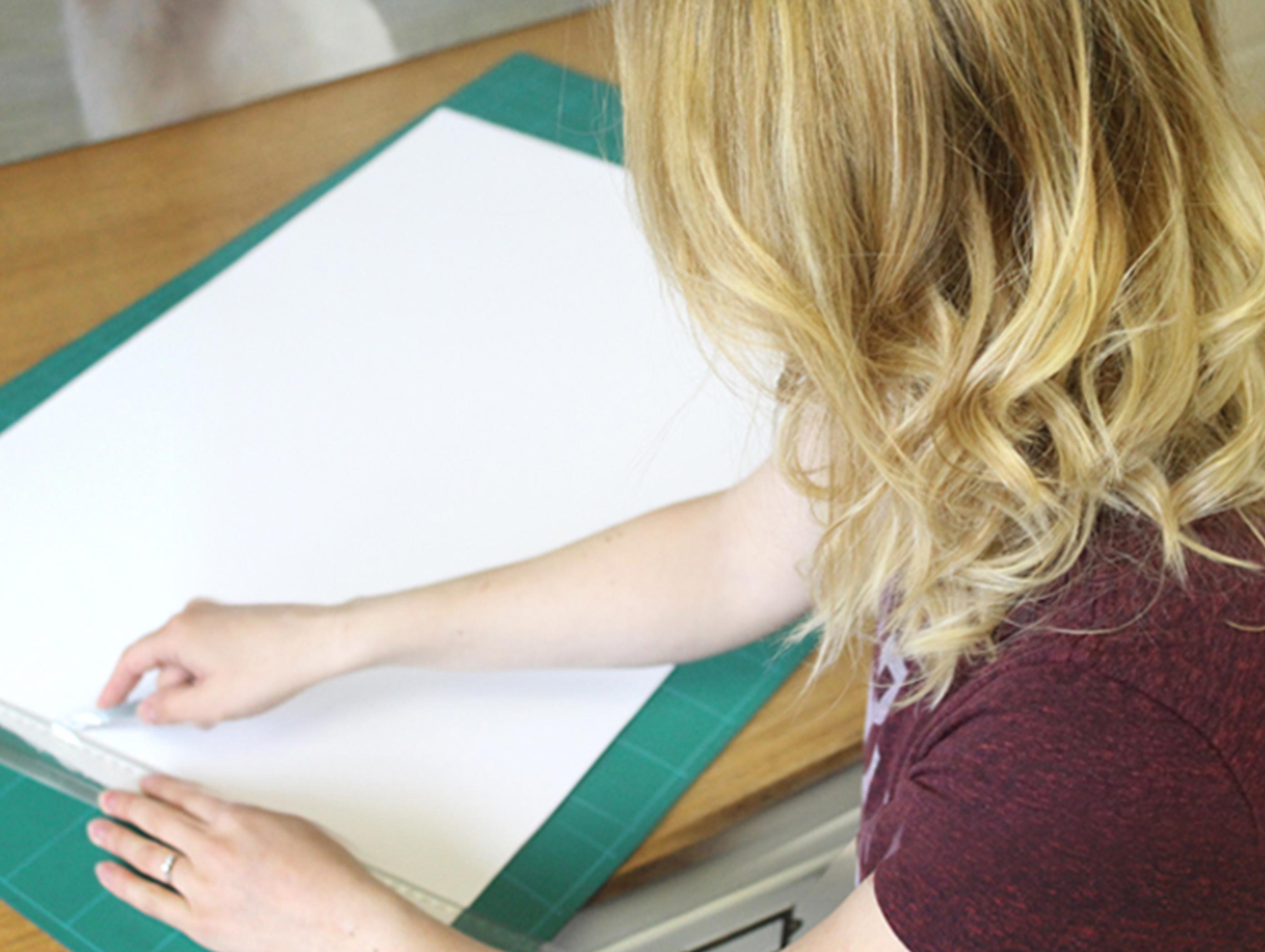 Melanie cutting paper in the studio